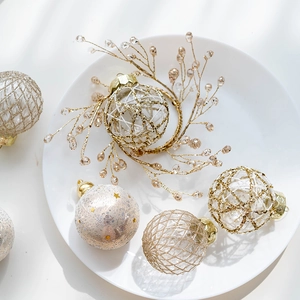 Champagne gold and red painted 6cm Christmas ball ornaments set on a white ceramic plate