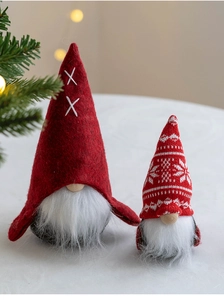 Close-up of two red Nordic Christmas gnomes with white embroidery and knitted hats