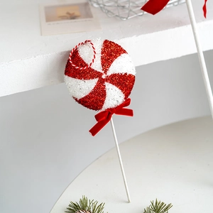 Red and white Christmas candy cane ornament with glitter finish and red velvet bow detail
