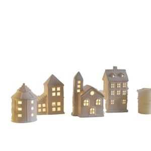 Set of four white ceramic miniature houses with warm LED lighting through windows