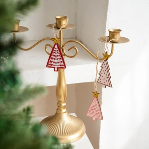 Set of Nordic wooden Christmas tree ornaments in red white and pink hanging on gold decor