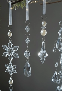 Detail of clear acrylic snowflake pendants with pearls and ribbon for Christmas tree
