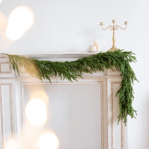 Realistische grüne Weihnachtsguirlande aus PE auf einem klassischen weißen Kaminsims