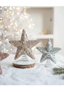 Detail of glittered star toppers with spring bases and natural wood stand for Christmas