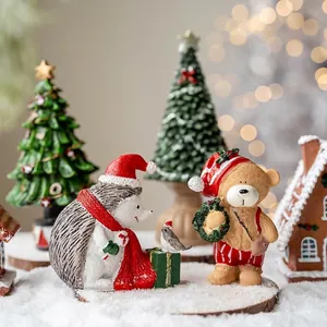 Miniature resin Christmas figurines featuring a hedgehog and bear in a snow scene