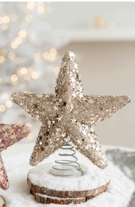 Macro view of champagne gold glitter Christmas tree topper star with silver spring base