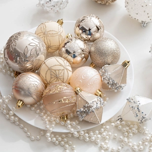 Champagne gold Christmas tree ornaments with matte and glitter textures on white tray