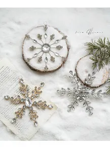 Close-up of sparkling acrylic snowflake ornaments with inlaid rhinestones on snow