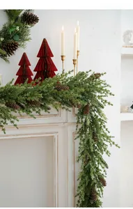Close-up of Christmas pine garland with natural pine cones on a white mantel fireplace