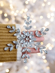 Sparkling acrylic snowflake ornament with rhinestones held in hand for Christmas decor