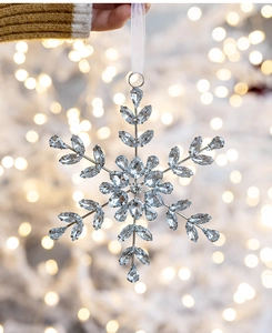 Close-up of snowflake Christmas ornament featuring acrylic rhinestones and silver frame