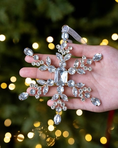 Detailed view of a golden snowflake ornament with sparkling crystals and hanging ribbon