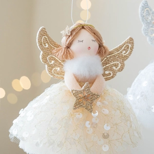 Christmas tree angel ornament with tulle skirt and golden star in warm bokeh background