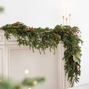 Lush Christmas garland with pine needles berries and cones on a white mantel fireplace