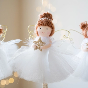 Christmas angel doll with white lace dress and gold star on festive bokeh background