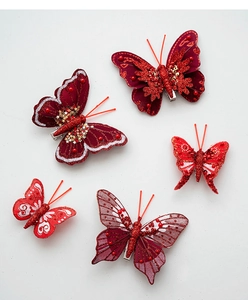 Dettaglio di fermagli a farfalla in tessuto rosso con tulle, paillettes e perline