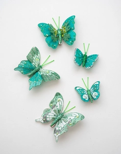 Dettaglio di fermagli per capelli a farfalla color tiffany con glitter e perle