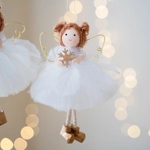 Christmas angel doll decoration with white tulle dress and golden wings on festive bokeh