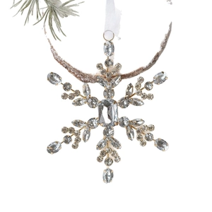 Golden acrylic snowflake ornament with inlaid crystals hanging on a Christmas tree branch