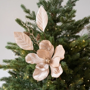 Champagne velvet Christmas flower with gold sequins and decorative foliage on tree