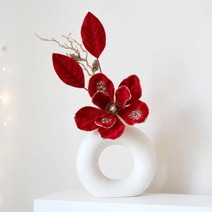 Christmas velvet flower decoration in white ring vase with gold glitter and red leaf accents