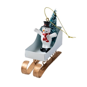 Christmas snowman on white metal sleigh ornament with green tree and gold hanging string