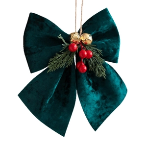 Dark green velvet Christmas bow ornament with gold bell, red berries and pine needles