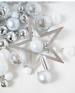 Close-up of silver and white Christmas ornaments with matte, glossy, and glitter textures