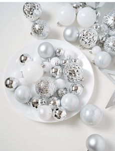 Detailed view of silver and white Christmas baubles in matte, glossy, and faceted textures
