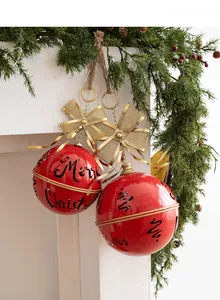 Detail view of large red metal Christmas bells with Merry Christmas lettering and gold bows