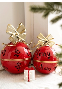 Close-up of red metal Merry Christmas bells with gold bows and star light decoration