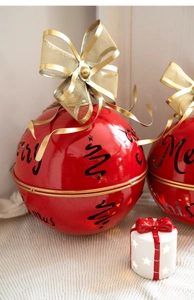 Red metal Merry Christmas bell ornament with gold bow on white fabric texture