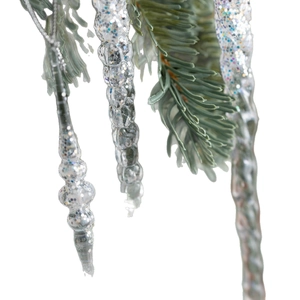 Glittery acrylic icicle drops hanging on a Christmas tree branch for festive holiday decor