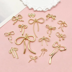 Primer plano de colgantes de lazo dorados con varias texturas para creación de joyas DIY
