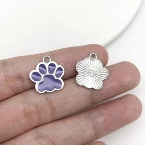 Detailed view of purple cat paw charm with silver metal frame and engraved back texture