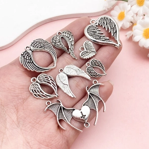 Silver punk wing heart pendants set displayed on hand for DIY necklaces and accessories