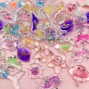 Breloques d'animaux marins en résine lumineuse avec paillettes sur fond rose
