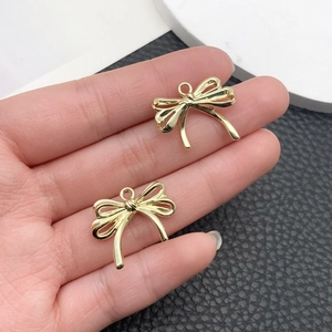 Dos colgantes de lazo dorados para la creación de collares y joyas DIY
