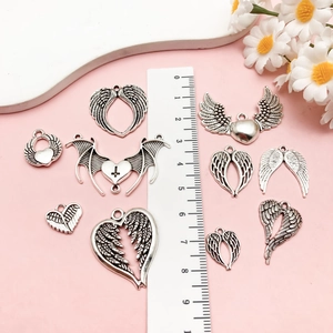 Macro shot of 10 punk heart wing pendants in bright silver alloy for DIY jewelry