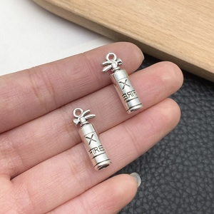 Detailed close-up of a mini silver fire extinguisher pendant charm for DIY jewelry