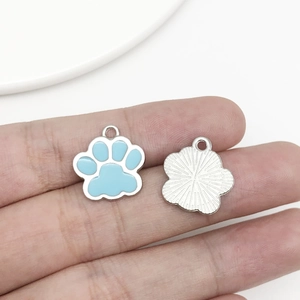 Detail of blue cat paw alloy pendant showing front enamel and back metal texture