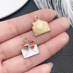 Detailed view of alloy envelope pendant with red hearts for DIY jewelry making