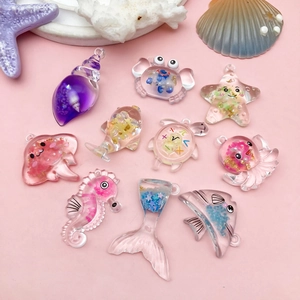 Vue détaillée de breloques marines en résine avec paillettes et décors coquillages