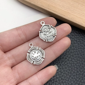 Detailed close-up of retro silver fire department charms with intricate badge engraving