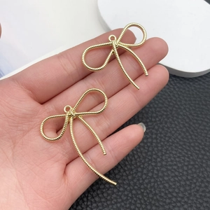 Vista macro de dijes de lazo dorado con textura en espiral para joyería DIY