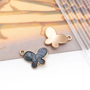 Macro view of gold butterfly alloy pendants with black marble enamel for DIY jewelry