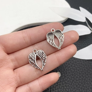Detail of vintage silver heart wing charms for DIY punk necklaces and accessories
