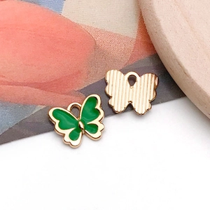 Détail de pendentifs papillons en émail vert et rayures dorées pour bijoux DIY