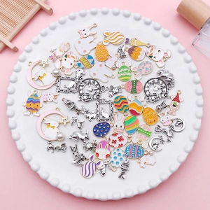 Flat lay of colorful Easter enamel egg and bunny alloy pendants for DIY jewelry making