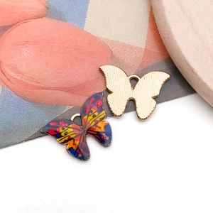 Détail de pendentifs papillons colorés et dorés pour la création de bijoux DIY